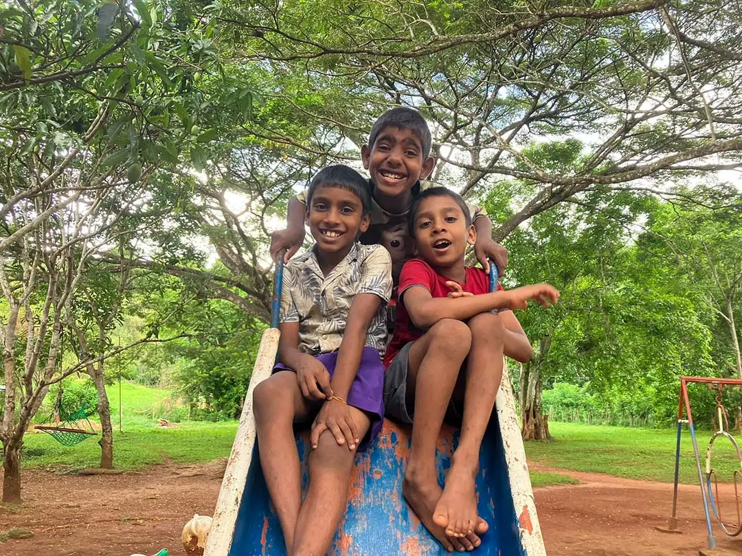 drie vrolijke jongetjes zitten op een glijbaan