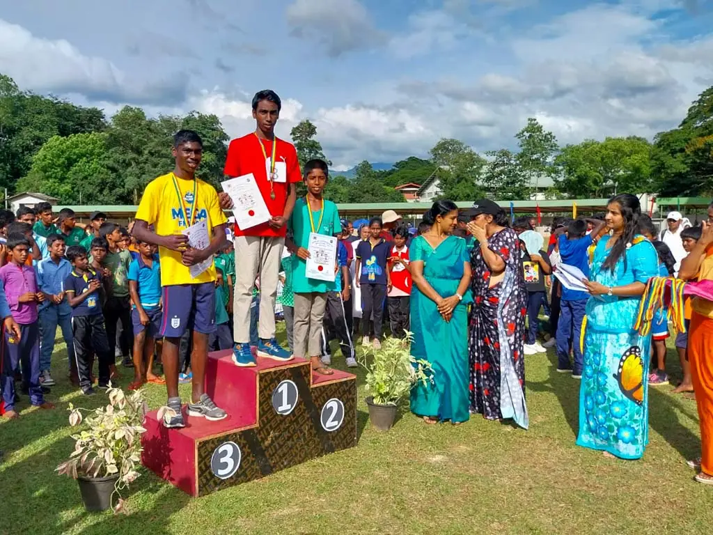 Drie jongens staan op het erepodium tijdens de prijsuitreiking van de sportdag.